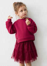 Load image into Gallery viewer, Girl wearing loose raspberry red sweatshirt and a tulle tiered skirt with sparkle dtails