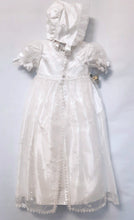 Load image into Gallery viewer, A beautiful three piece Christening outfit comprising a simple white satin gown with cap sleeves, an embroidered organza lace effect "coat" to wear over it, and a matching bonnet. The "coat"  has puff sleeves decorated with bows. It is fastened with pearl buttons and loops and is edged in guipure style lace trimming. The bonnet is fastened with velcro and is edged with a pretty organza frill. Buy on;ine on kidstuff.ie