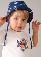 Load image into Gallery viewer, Child wearing a white t-shirt with a fish design, navy shorts with fish patterns, and a navy bucket hat with fish designs  mayoral 1667 boy's outfit available to buy on kidstuff.ie
