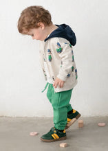 Load image into Gallery viewer, Child wearing a hoodie with cartoon designs and green pants on a plain background
