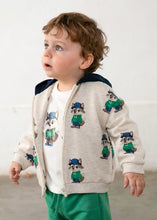Load image into Gallery viewer, Child wearing a cream jacket with cartoon raccoon designs and green  jog bottoms
