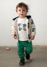 Load image into Gallery viewer, Child wearing a jacket with raccoon designs and green pants.
