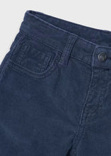 Load image into Gallery viewer, Close-up of dark blue corduroy trousers showing the waistband, belt loops, front pocket, and a dark metal button .
