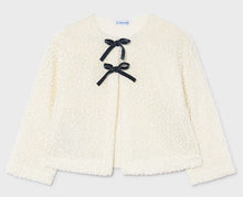 Load image into Gallery viewer, An off-white textured bouclé jacket with long sleeves and two navy ribbon bows tied at the center front
