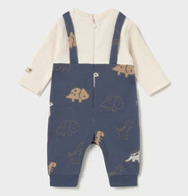 Load image into Gallery viewer, Back view of a baby's long-sleeve footless romper. The top portion is cream, while the lower portion and shoulder straps are denim- blue with a pattern of small dinosaur silhouettes in tan and white. available on kidstuff.ie

