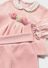 Load image into Gallery viewer, A baby girl's two-piece footed set in light pink velour, featuring a long-sleeve top with a cream  floral Peter Pan collar and a pink and beige flower applique at the chest, paired with matching pink footed pants.
