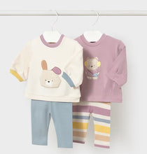 Load image into Gallery viewer, Two children's long-sleeve top and leggings  hanging on white hangers. The left set is cream with a bunny face applique, lavender collar trim, yellow sleeve accents, and aqua pants. the set on the right has a mauve top with teddybear applique and striped leggings
