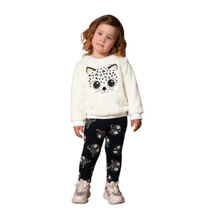 Milon girl's black and winter-white sweatshirt and leggings outfit with a pussycat motif. This cosy top is fully lined in cotton jersey. The outer layer is the softest plush fur fabric with a cute cat face embroidered on the front in black and white with gold ears and a bobble nose. The stretchy leggings are black with a white pussycat print all-over and an elasticated waist for comfort. Made by Milon and available on kidstuff.ie