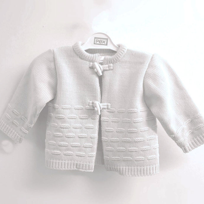 White cardigan for baby. White baby cardigan with toggles fastening.White baby cardigan by Pex.