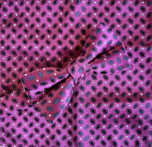 Boy's bow tie and pocket square in magenta brocade patterned with dark navy and a tiny silver grey dot. The necktie is on an adjustable band for a comfortable fit from about 7 years to 14 years and has a hook and bar fastening. Suitable for special occasions including First Communions and weddings. 