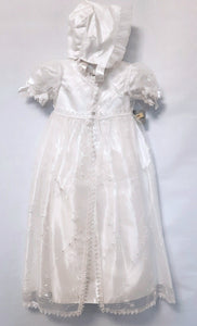 A beautiful three piece Christening outfit comprising a simple white satin gown with cap sleeves, an embroidered organza lace effect "coat" to wear over it, and a matching bonnet. The "coat"  has puff sleeves decorated with bows. It is fastened with pearl buttons and loops and is edged in guipure style lace trimming. The bonnet is fastened with velcro and is edged with a pretty organza frill. Buy on;ine on kidstuff.ie
