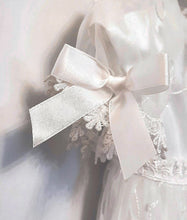 Load image into Gallery viewer, A beautiful three piece Christening outfit comprising a simple white satin gown with cap sleeves, an embroidered organza lace effect &quot;coat&quot; to wear over it, and a matching bonnet. The &quot;coat&quot;  has puff sleeves decorated with bows. It is fastened with pearl buttons and loops and is edged in guipure style lace trimming. The bonnet is fastened with velcro and is edged with a pretty organza frill. buy online on kidstuff.ie
